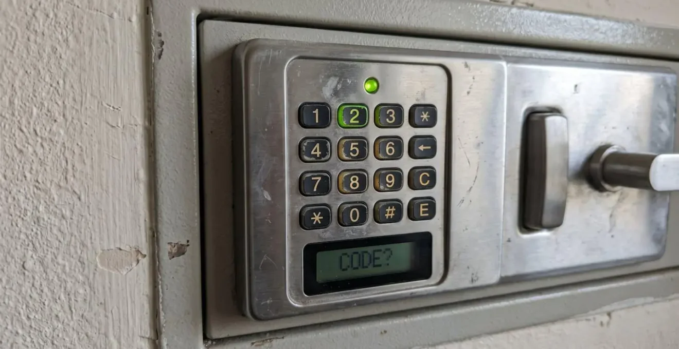 Gros plan sur un clavier numérique rétroéclairé d'une serrure électronique de coffre-fort dans une ambiance tamisée